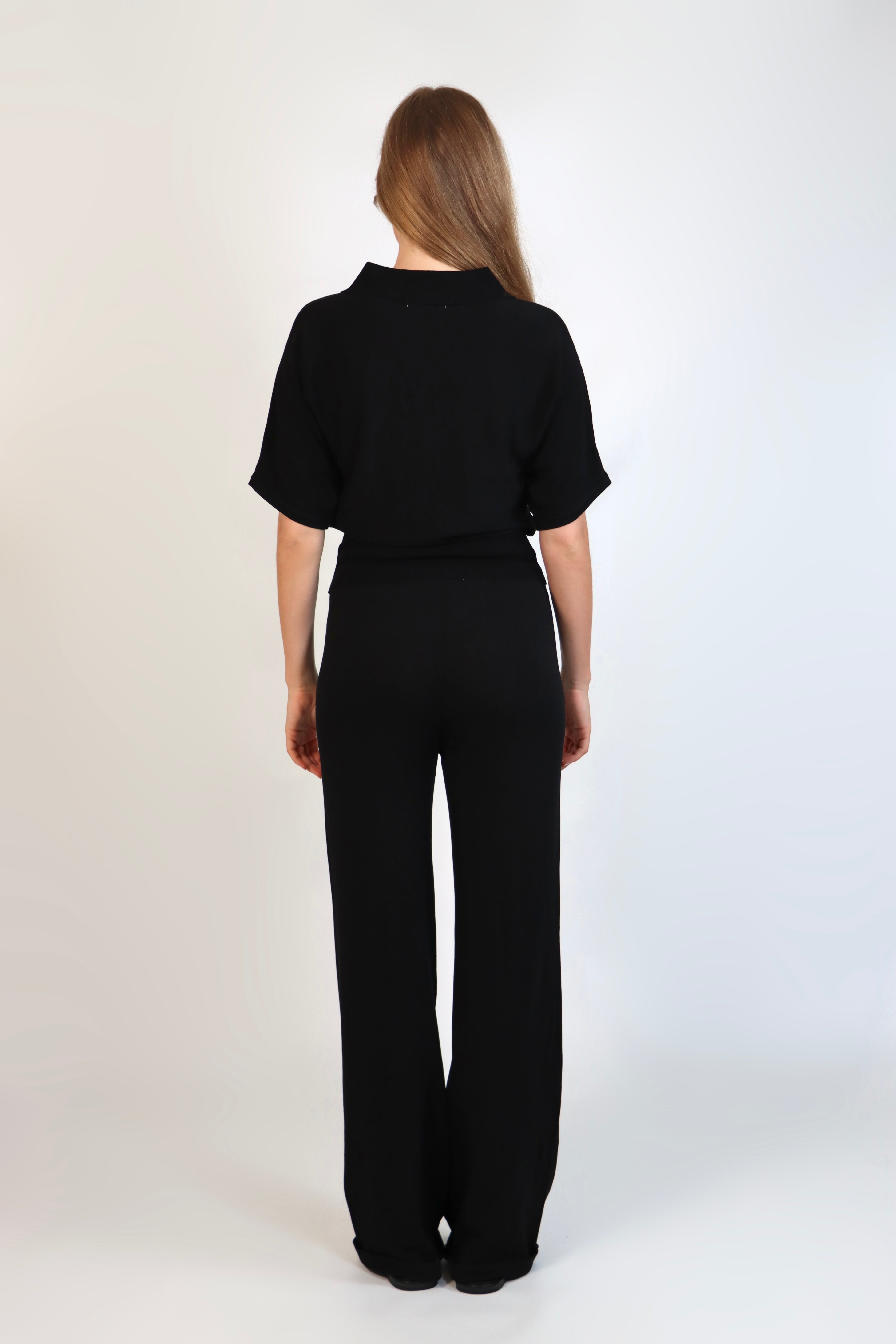 Black fine knit pants with a relaxed fit and soft stretch, women’s chic comfortable knit trousers.