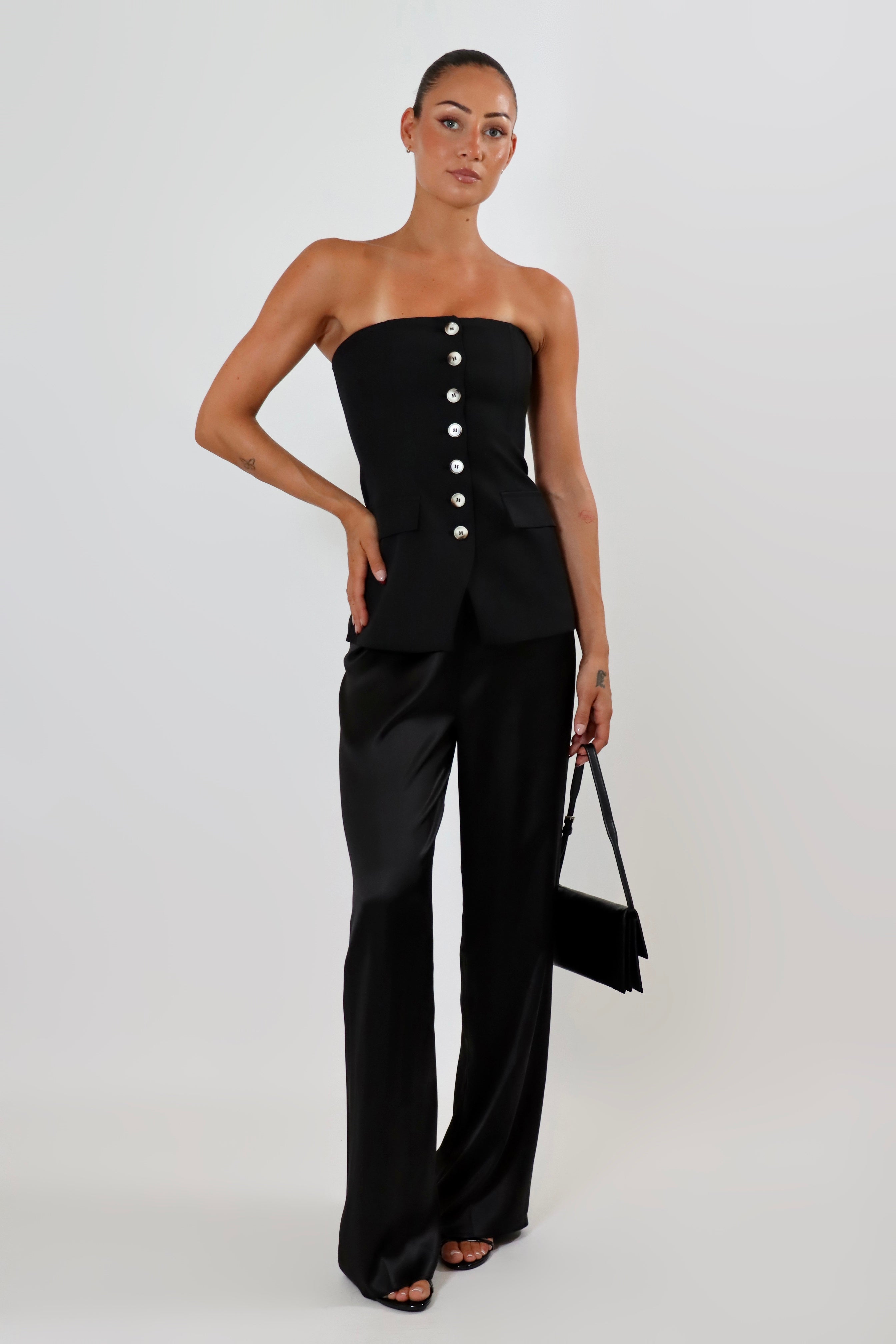 April Seven strapless vest top in black – structured strapless silhouette with button closure and flap pockets.