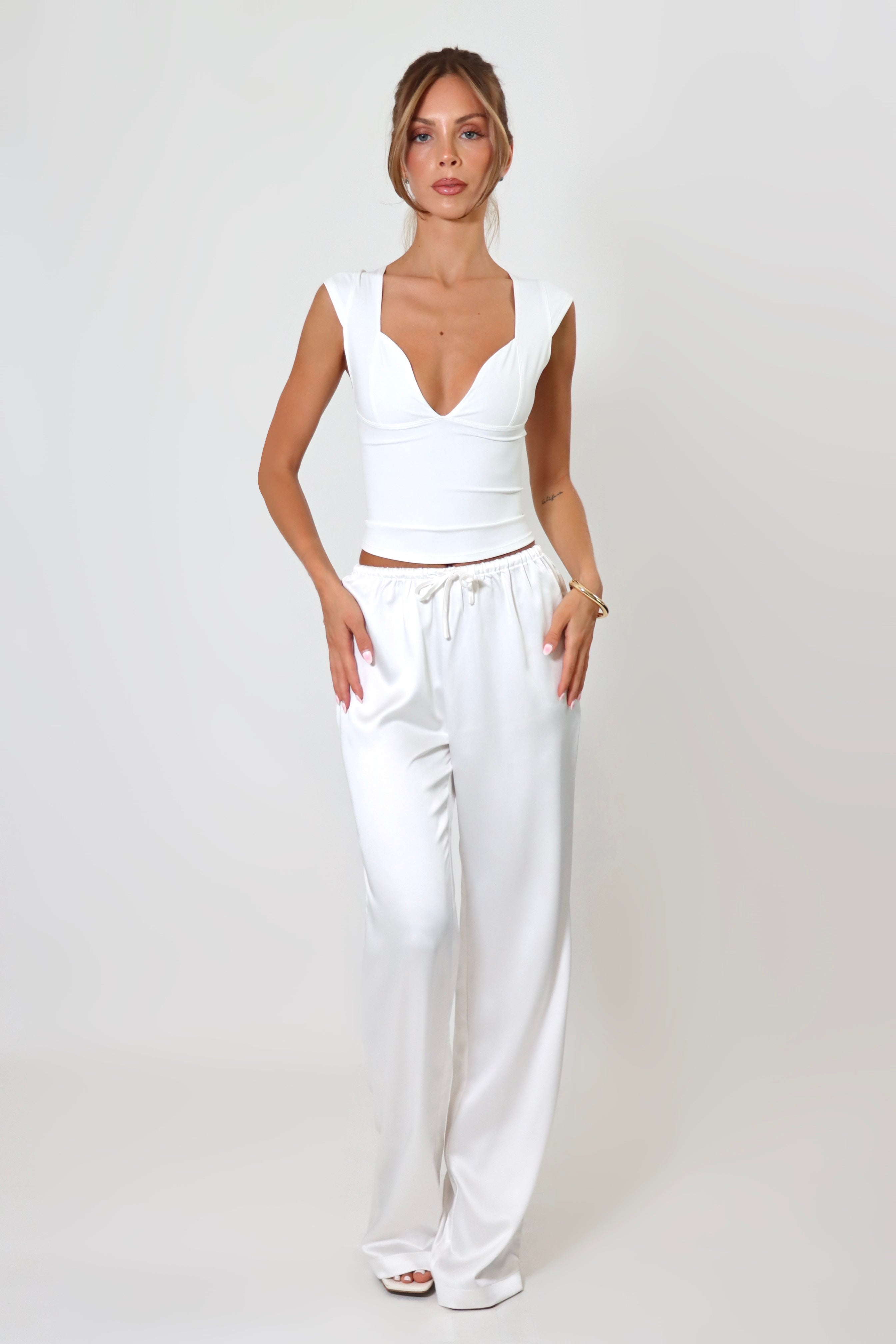 April Seven Beverly Top in white – minimalist fitted top with plunging neckline, cap sleeves, and sculpted silhouette.