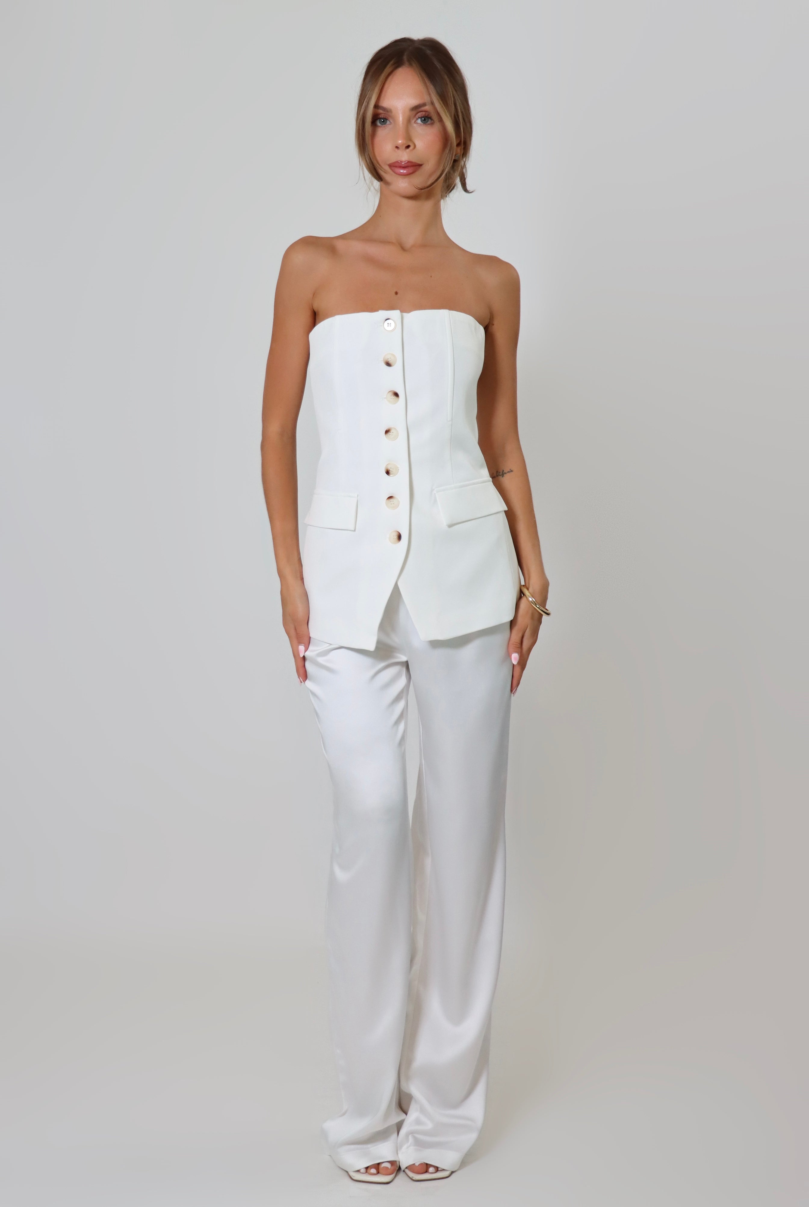 April Seven strapless vest top in white – tailored design with button-up front and flap pockets.