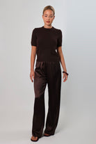 Elegant mid-waist wide-leg satin pants in a rich espresso brown shade, featuring a smooth, glossy finish and a fluid drape for a sophisticated, effortless look.