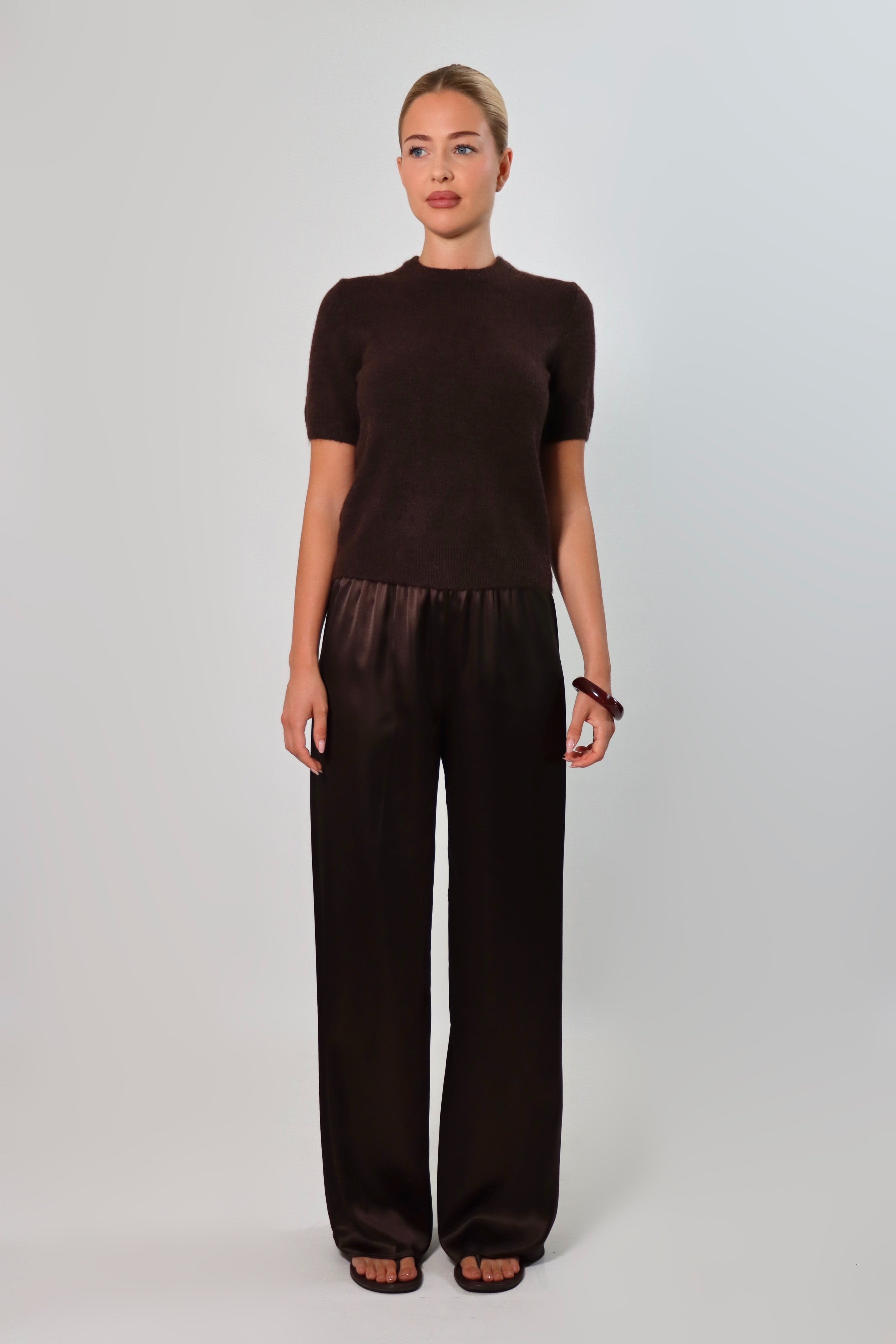 Elegant mid-waist wide-leg satin pants in a rich espresso brown shade, featuring a smooth, glossy finish and a fluid drape for a sophisticated, effortless look.