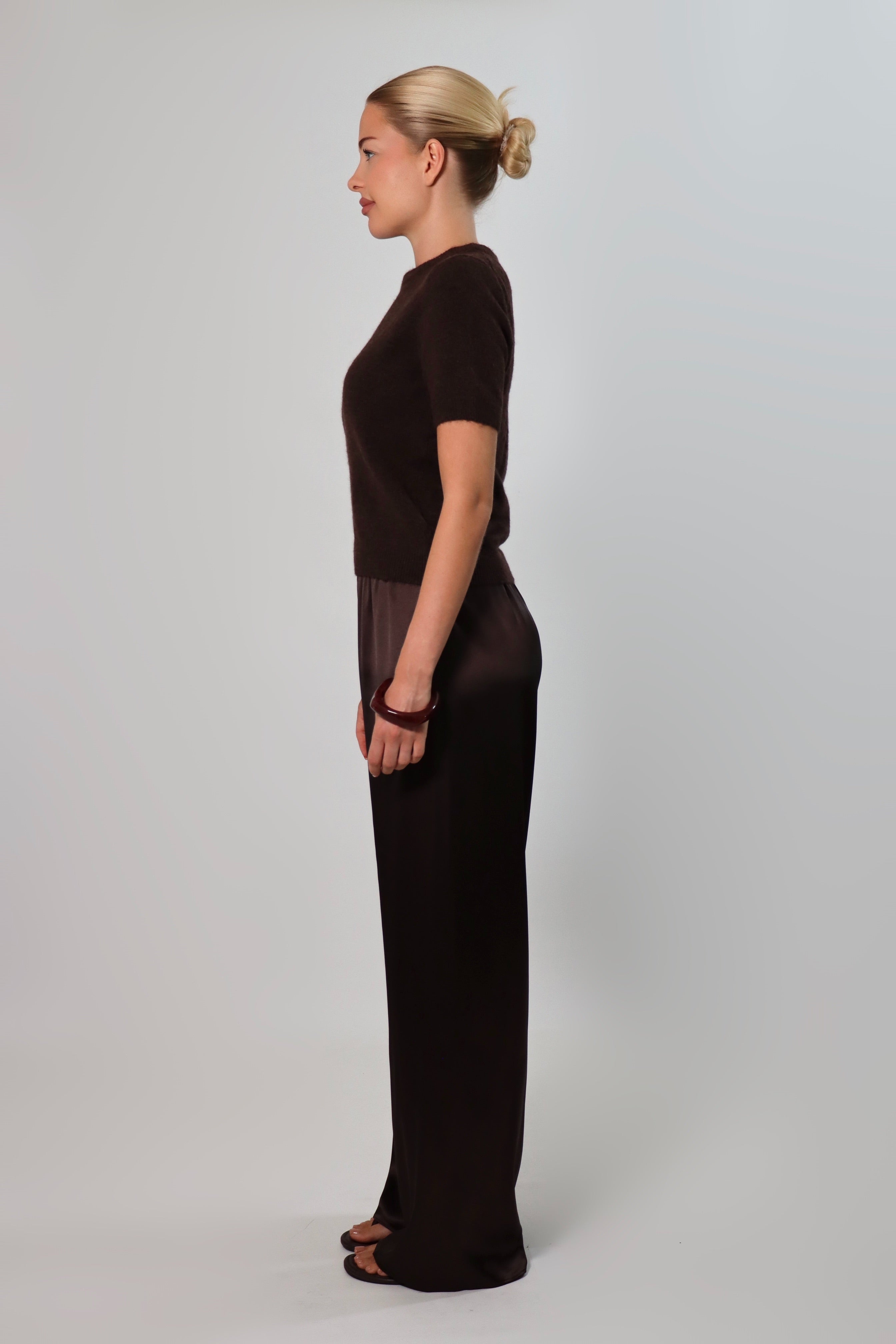 Elegant mid-waist wide-leg satin pants in a rich espresso brown shade, featuring a smooth, glossy finish and a fluid drape for a sophisticated, effortless look.