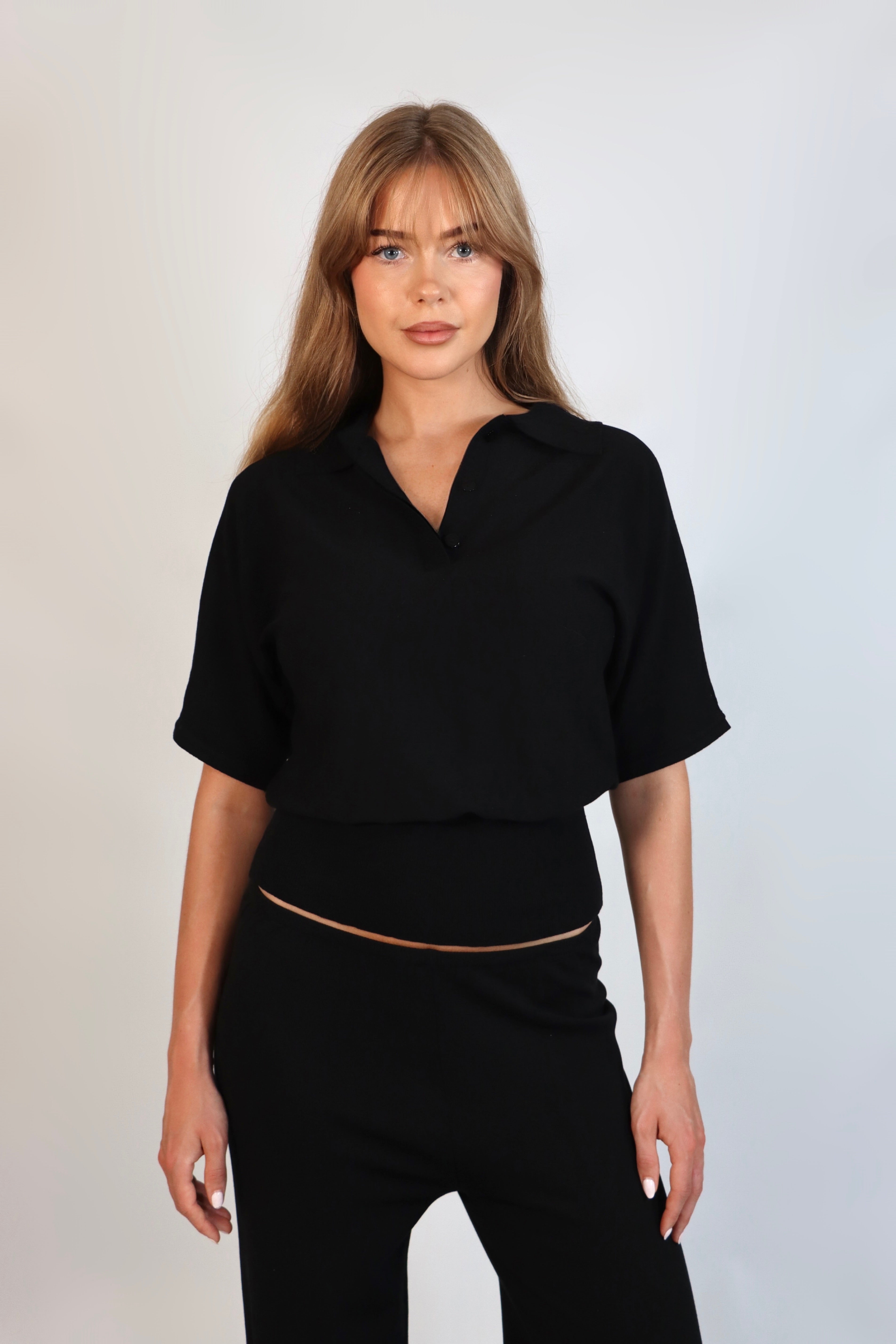 Black fine knit polo top paired with matching fine knit pants for an elevated knit set.