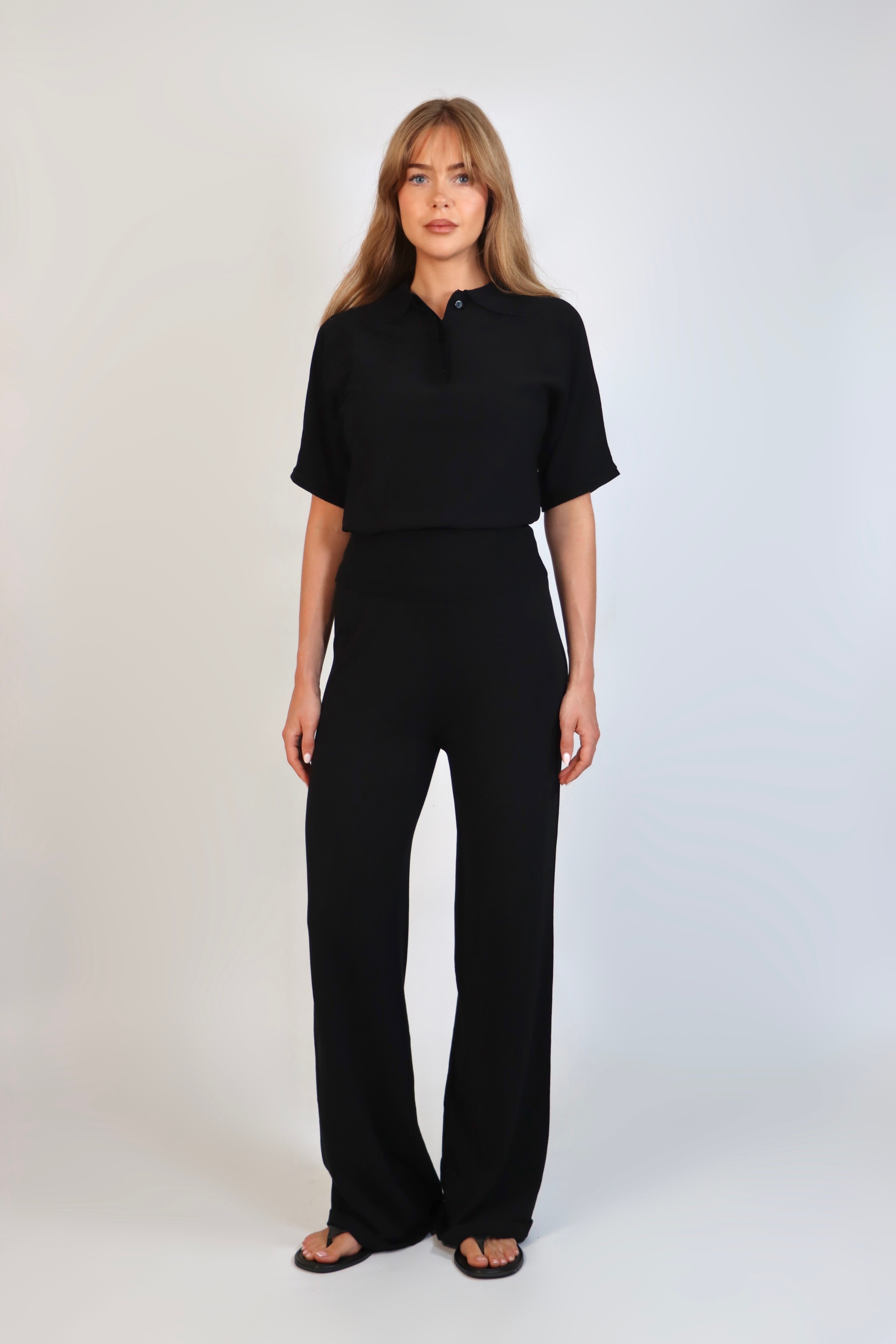 Black fine knit pants with a relaxed fit and soft stretch, women’s chic comfortable knit trousers.