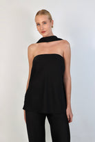 A model wearing a  black, strapless satin top with a matching scarf wrapped elegantly around her neck. The top has a clean, structured bodice and is paired with matching April Satin Pants for a monochromatic, sophisticated look against a plain white background.