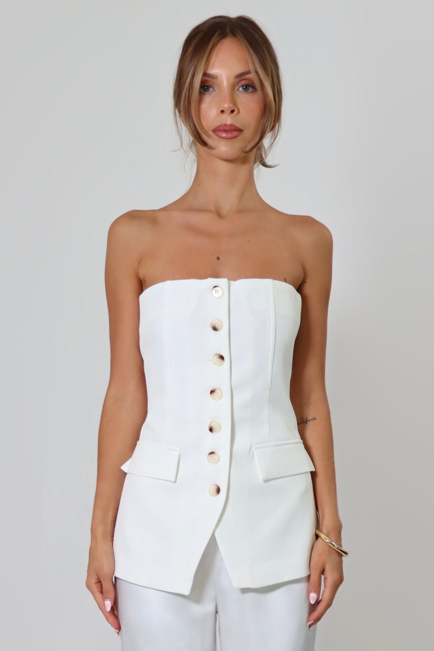 April Seven strapless vest top in white – tailored design with button-up front and flap pockets.